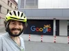 Paul wearing a bike helmet in front of a Google sign.