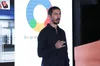 Ernesto, in a dark blue button down with the top two buttons undone, speaking at a Google marketing event.