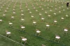 Spaced empty folding chairs at an outdoor event.