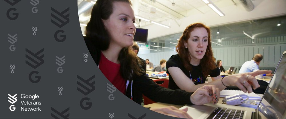 Two women look at a computer, with one in a Google T-shirt pointing at the screen.