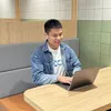 웬콩 엔지니어가 구글에 있는 한 부스에서 노트북에 무언가를 입력하며 미소를 짓고 있는 모습.