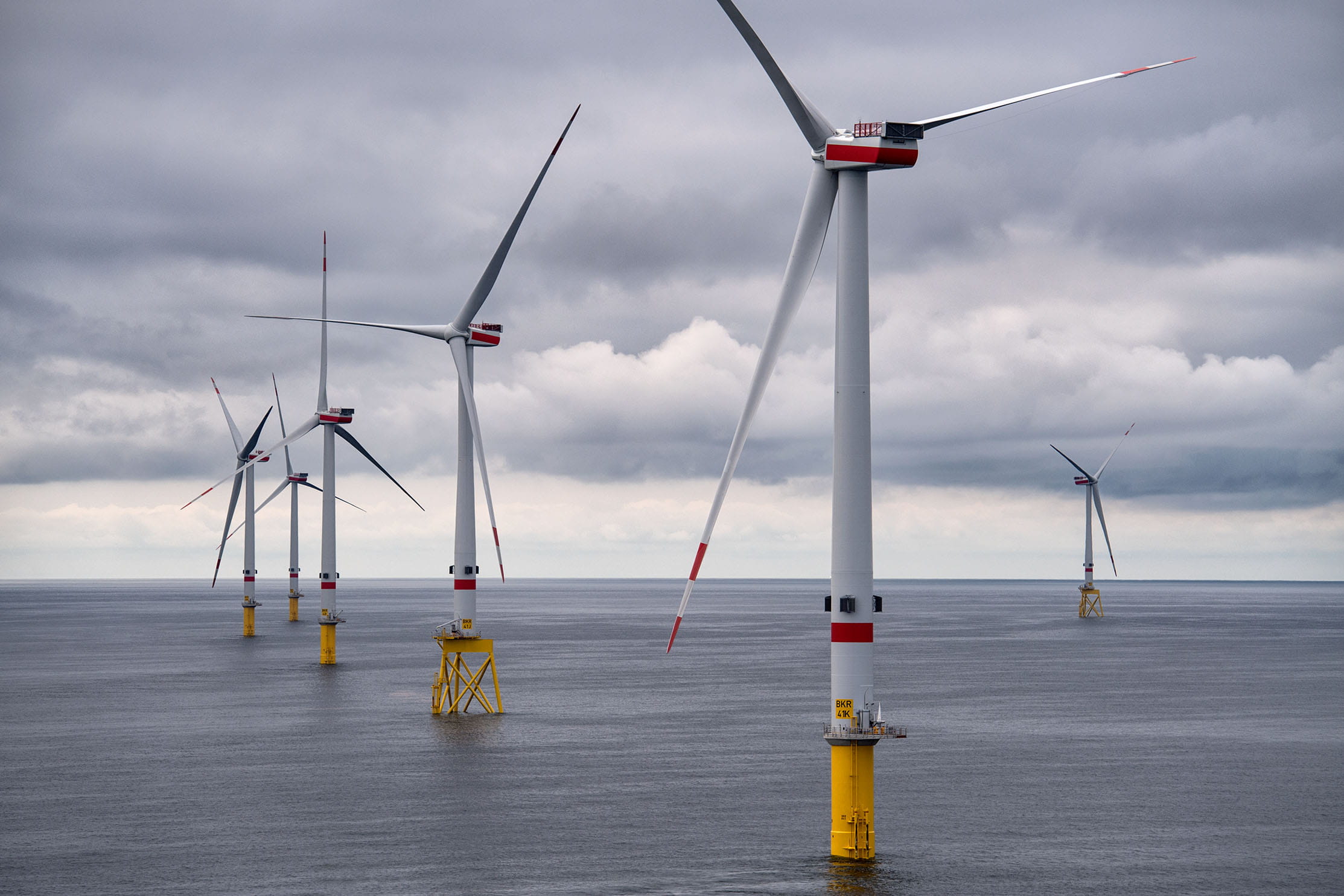 Bild von Windrädern in der Nordsee bei bewölktem Wetter.