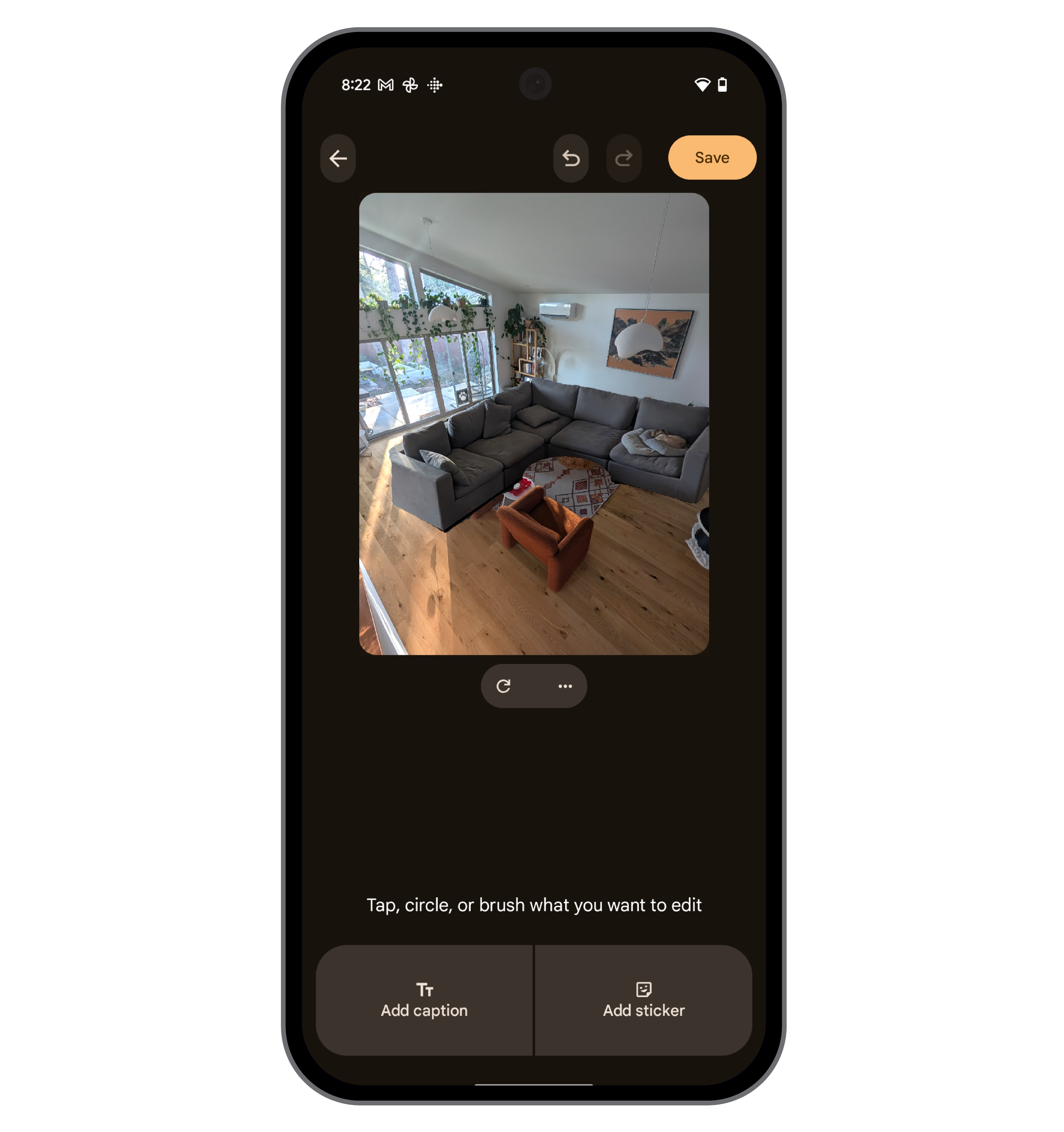 A smartphone screen displays an image editing interface. The image is a wide shot of a living room with a gray sectional sofa and hardwood floors. The sofa is made larger than in the first image. Below the image are buttons to add a caption or sticker. At the top right, a "Save" button is highlighted.