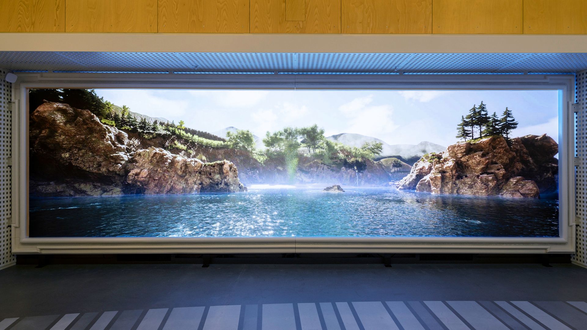 Digital screen: vivid landscape, blue water, rocky cliffs, mist.