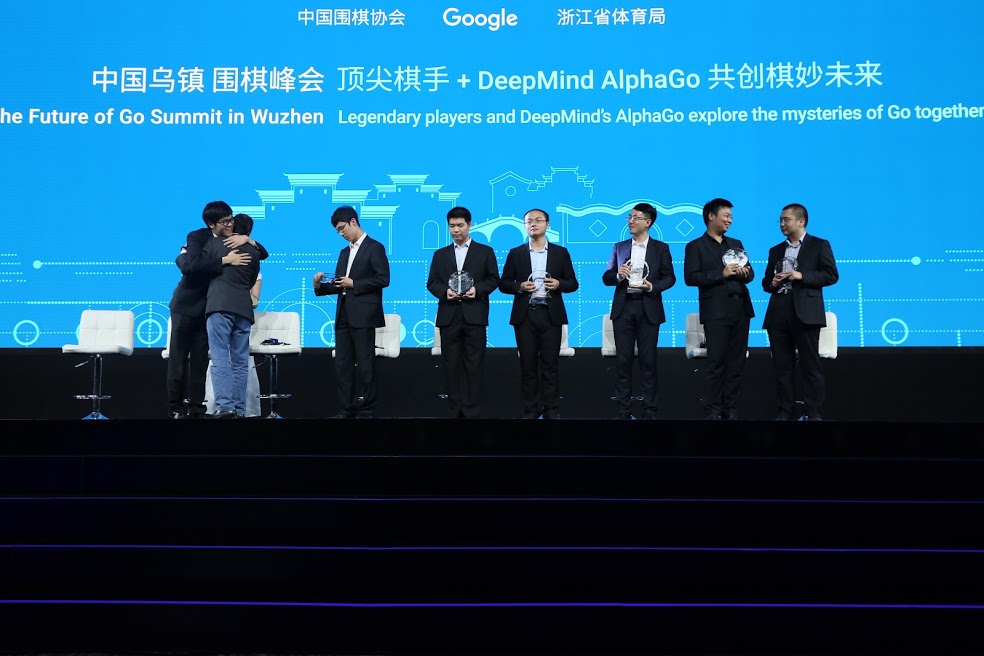 Two people embrace next to a group of others