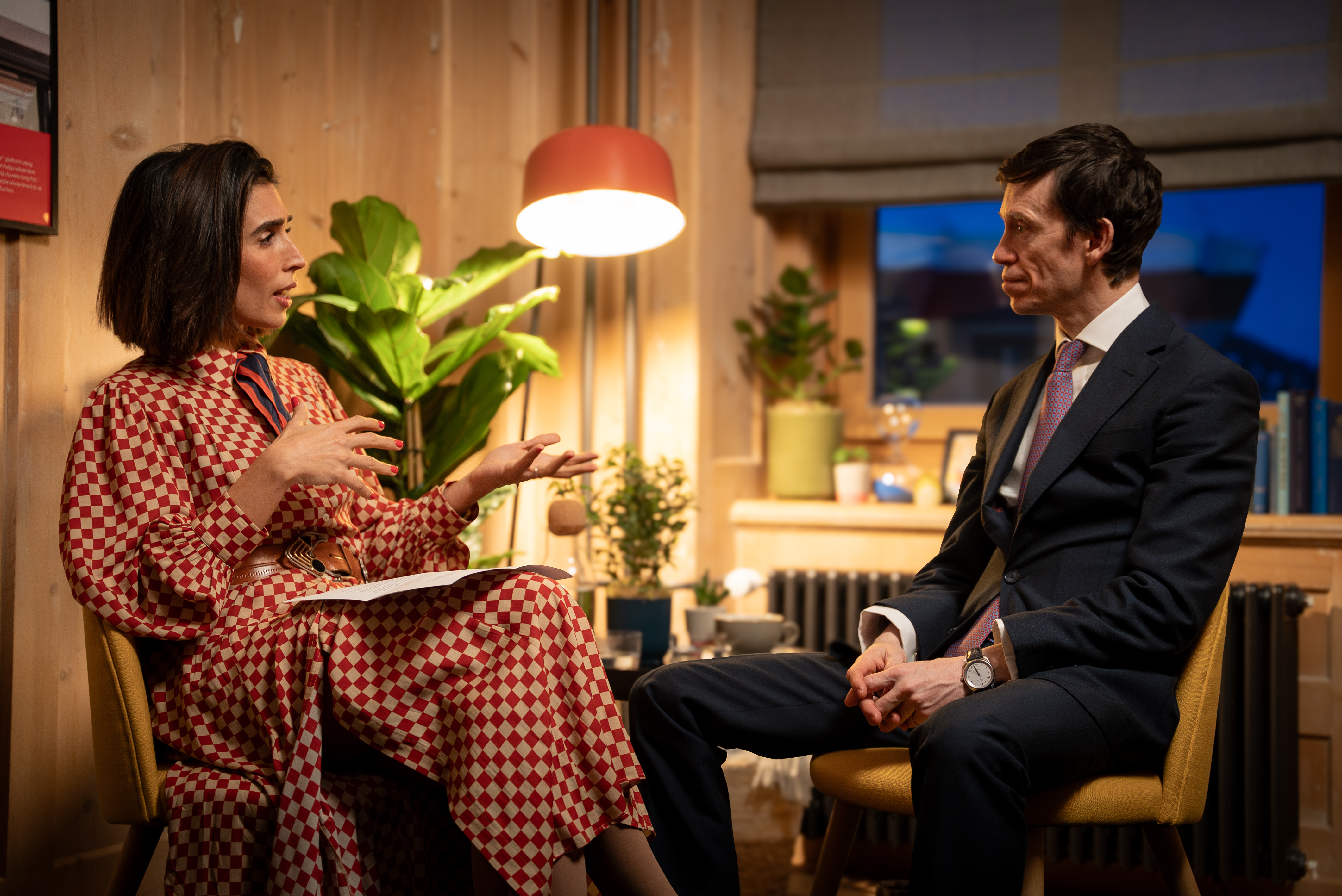 Two people seated in a room across from each other having a conversation