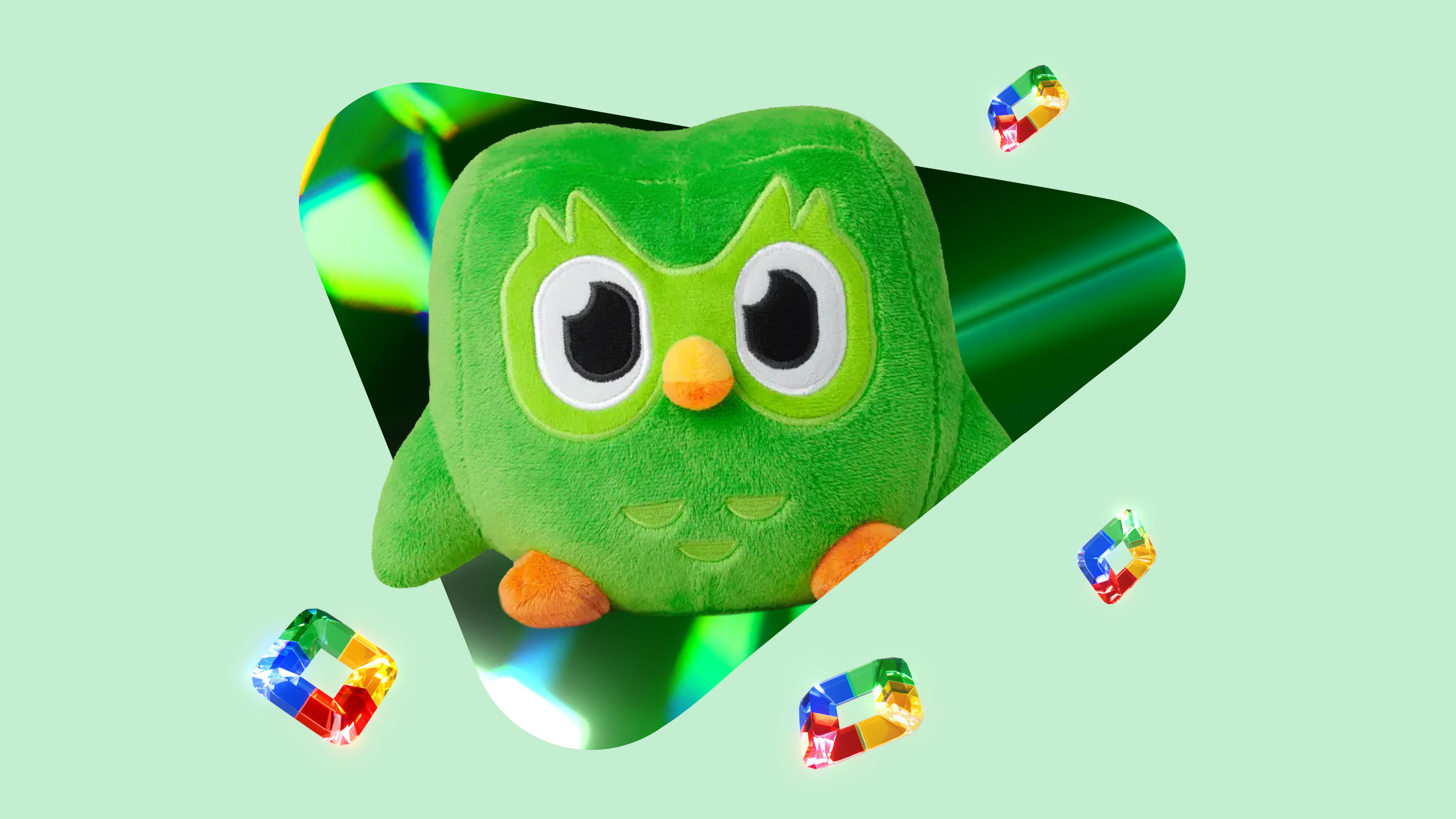 Green background with the Duolingo plushie coming out of a prism