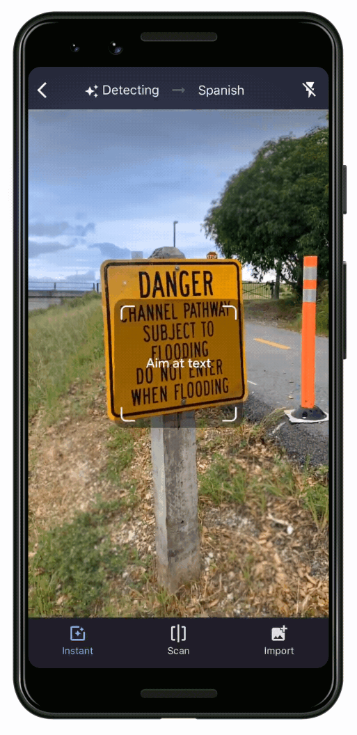 Ein Telefon zeigt ein Schild zu einer Flutwarnung, das von Englisch in Spanisch übersetzt wird