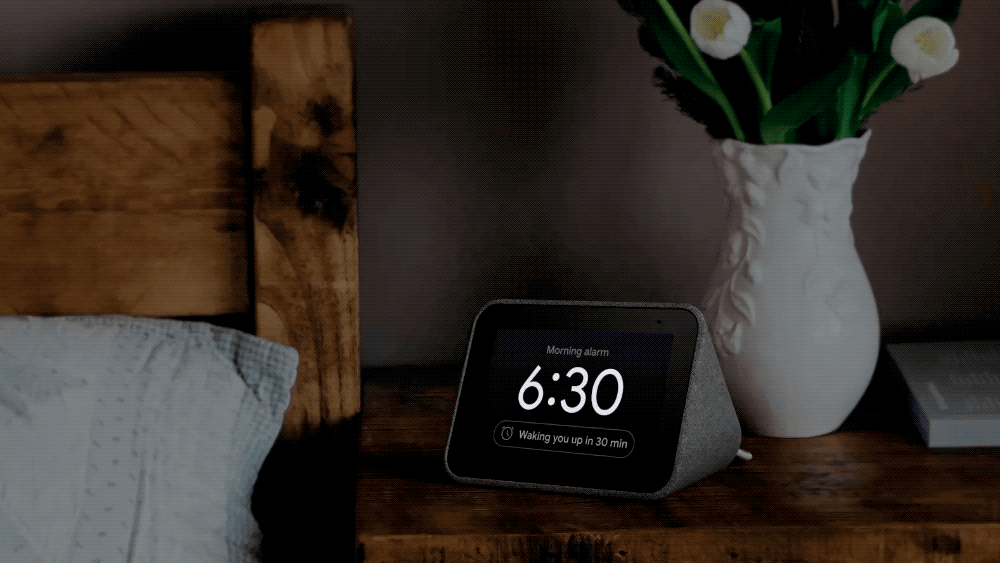 Animated GIF showing a Lenovo Smart Clock on a bedside table as the time elapses over a night.