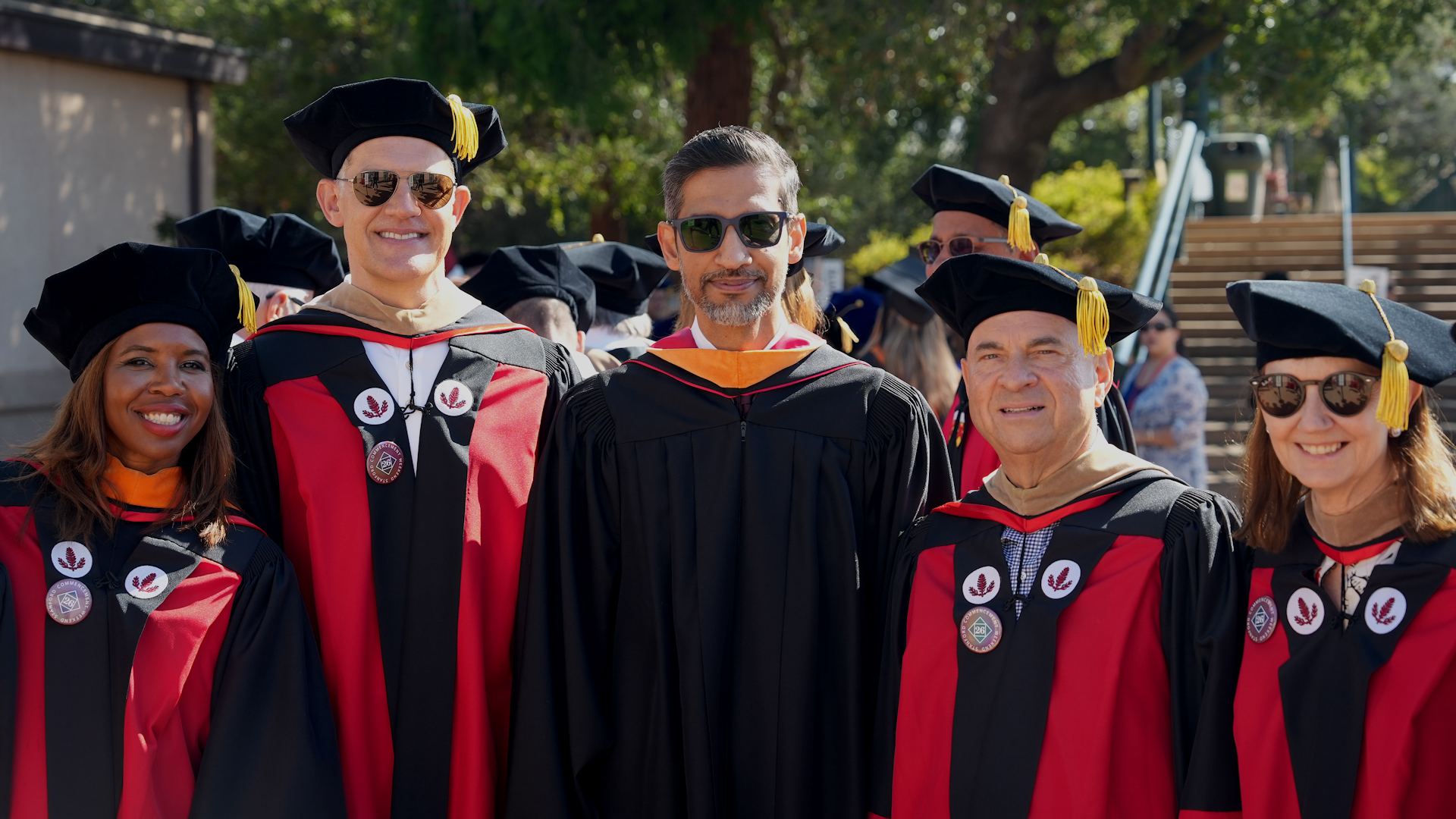 Sundar Pichai with a group in Stanford academic regalia.