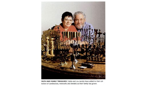 A man and woman sit behind a table of holiday items