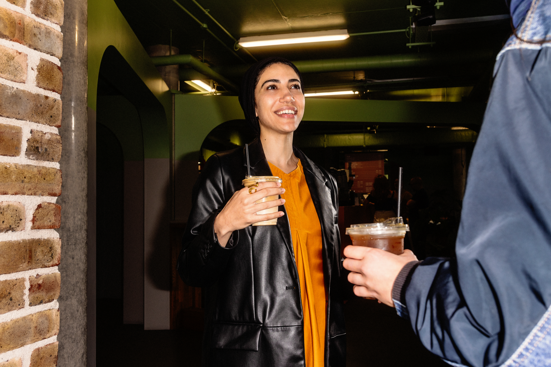 A smiling woman enjoying a coffee at Grindstone Coffee at Bolands Mills.