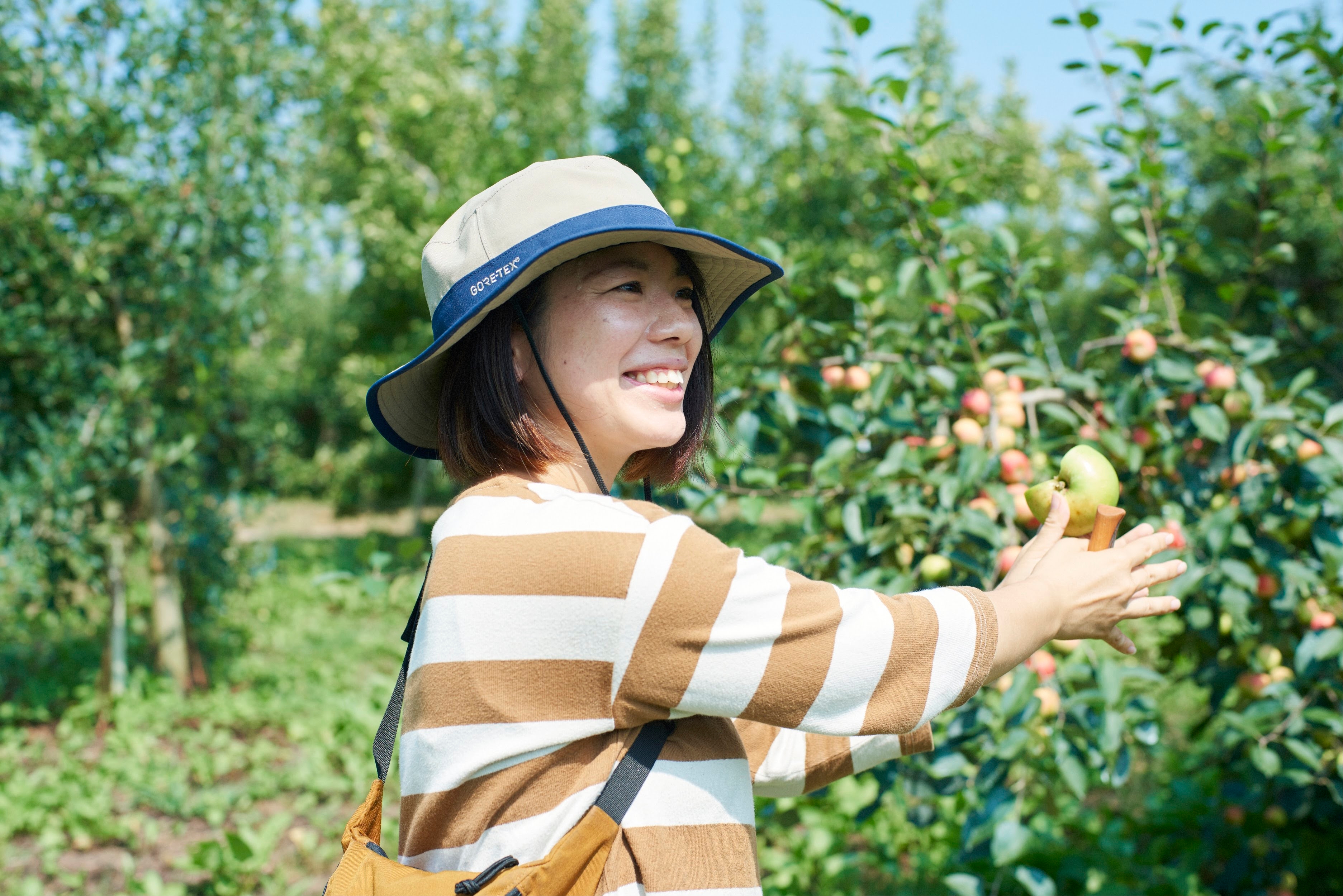 A photograph of Yamashita Fruit Garden CEO, Eri Yamashita, in her orchard