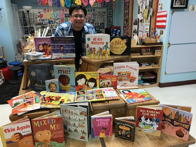 Mr. Yung standing behind a bookshelf