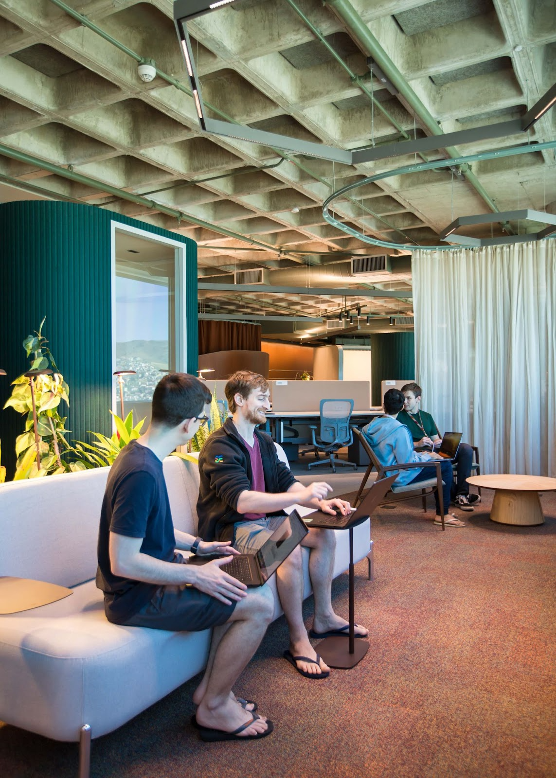 Funcionários do Google estão sentados na área de convivência do novo andar do escritório de Belo Horizonte