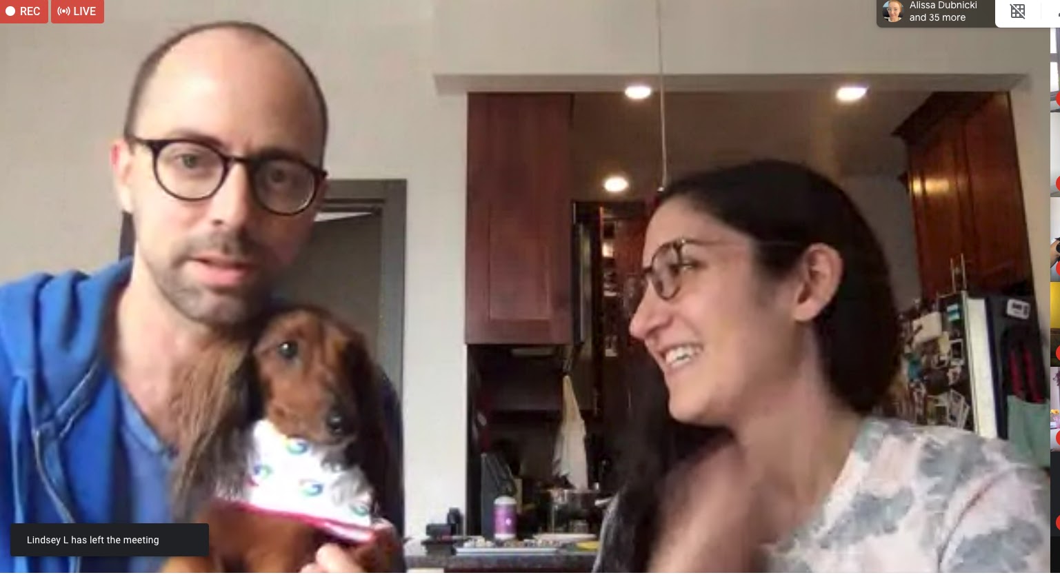 Dog and two humans sitting.