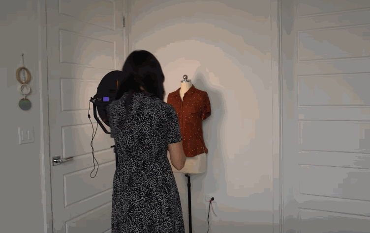 Animated GIF showing a woman in a white room placing different clothing items on a mannequin and taking photos of them.