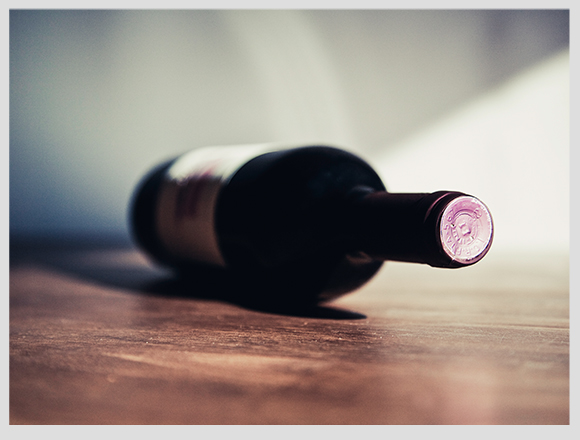 botella de vino acostada sobre una mesa