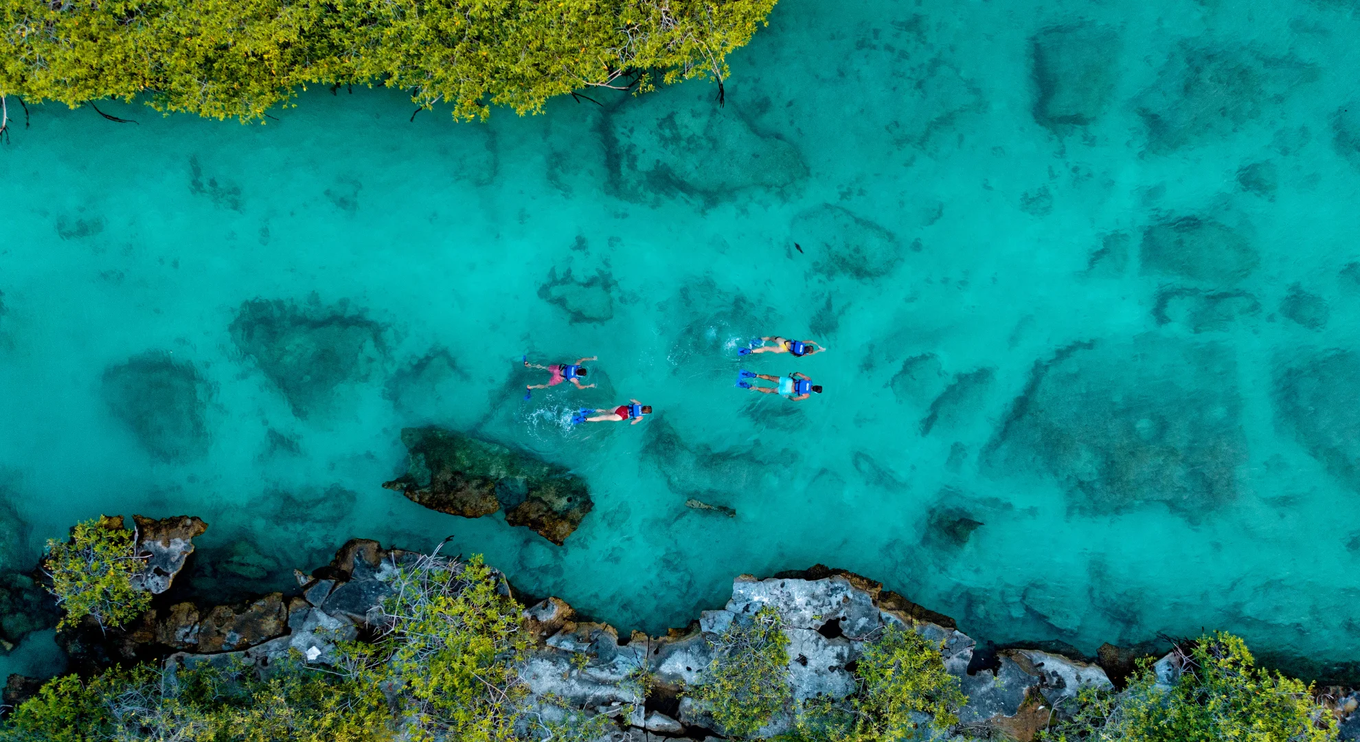 Vista de dron de personas haciendo snorkeling en la caleta/laguna de Yal-Kú