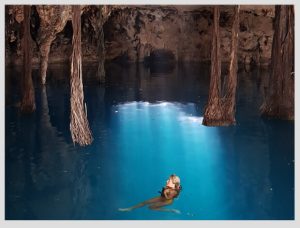 mujer nadando en un cenote de caverna