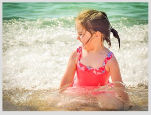 niña jugando en el mar