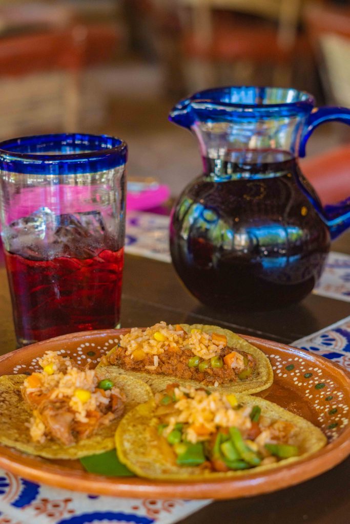 tacos de guisado acompañados de agua de jamaica