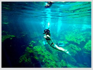 mujer haciendo snorkel en cenote