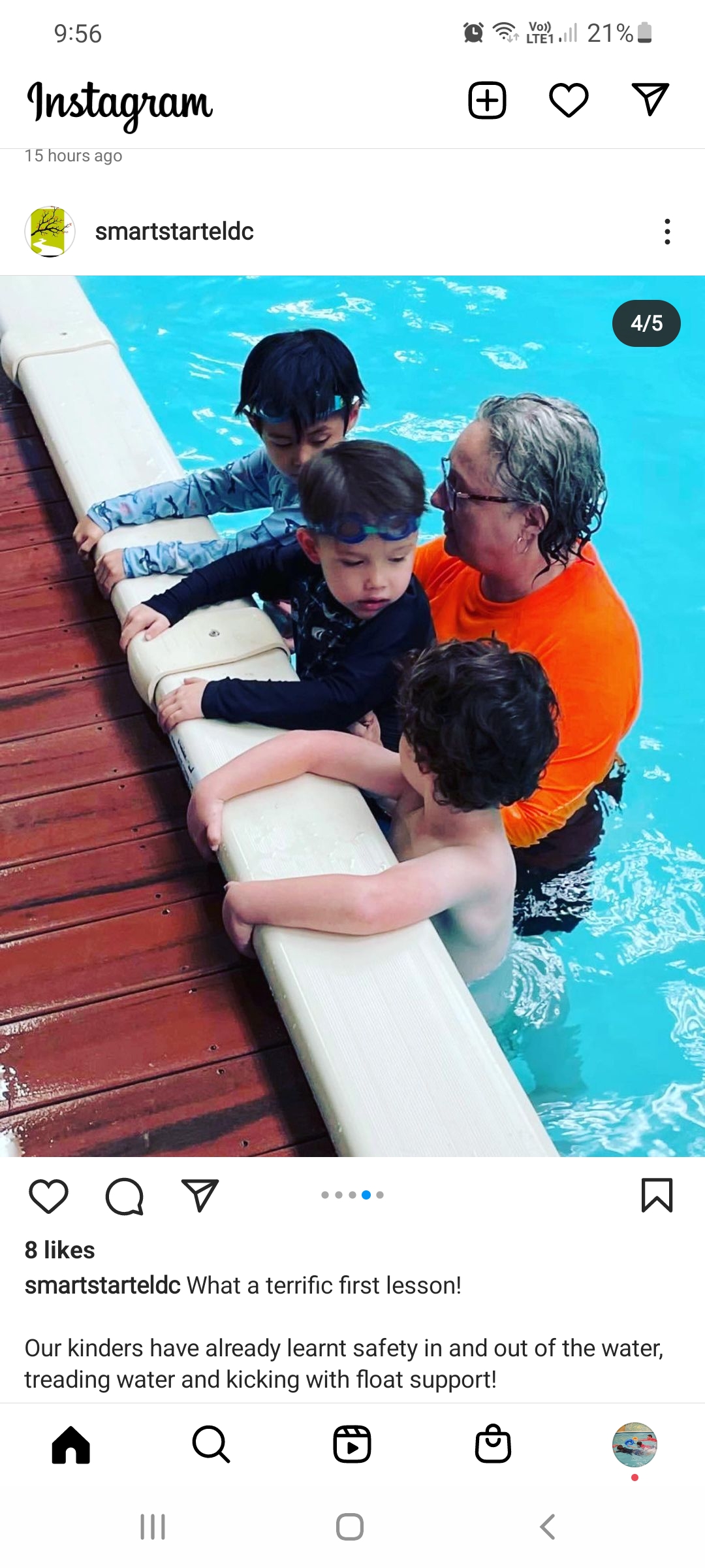 A trainer is helping young children learn to swim in a pool.
