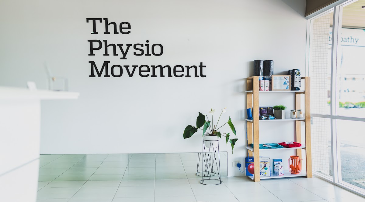 This photo shows a clean and minimalist interior of what appears to be a physiotherapy clinic or movement studio with branding prominently displayed o