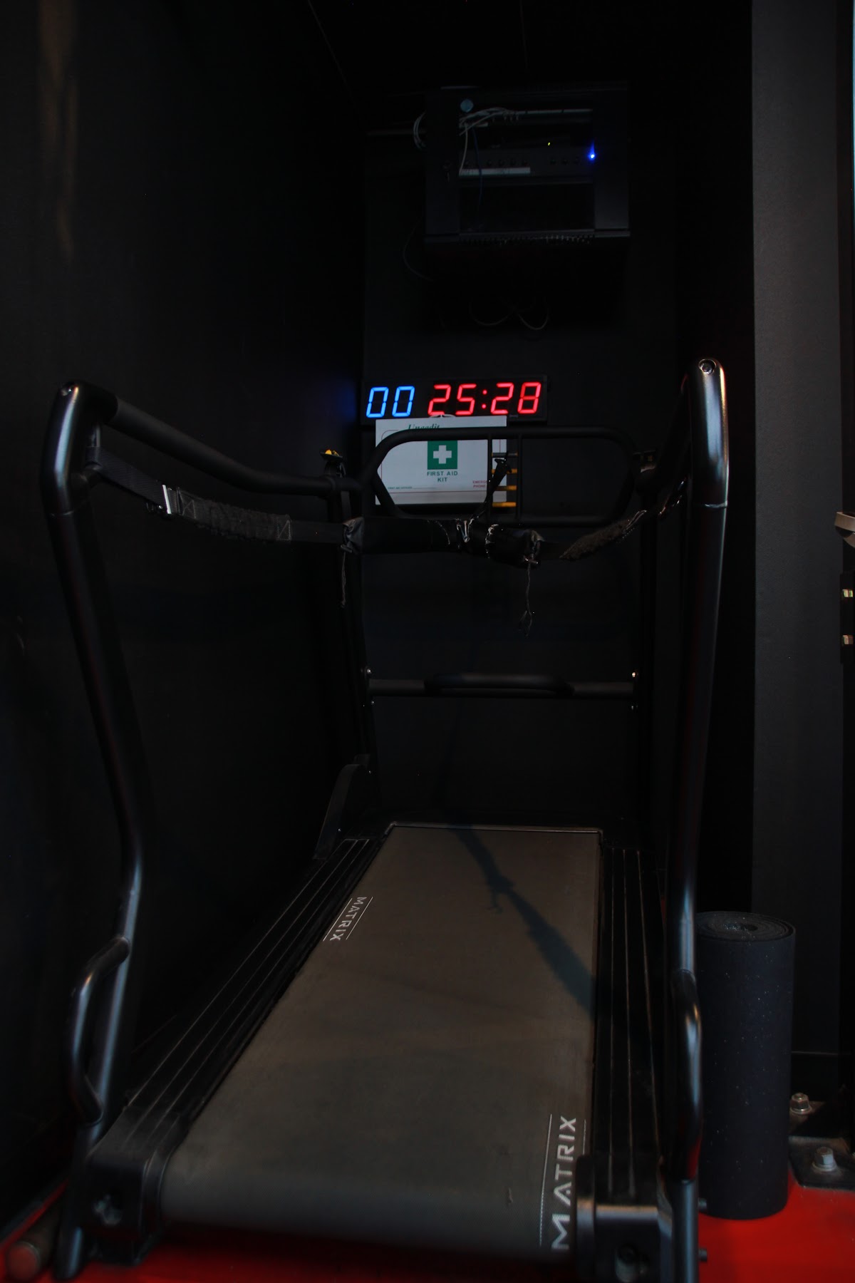 A close-up shot of a treadmill with a digital timer and medical symbols visible.