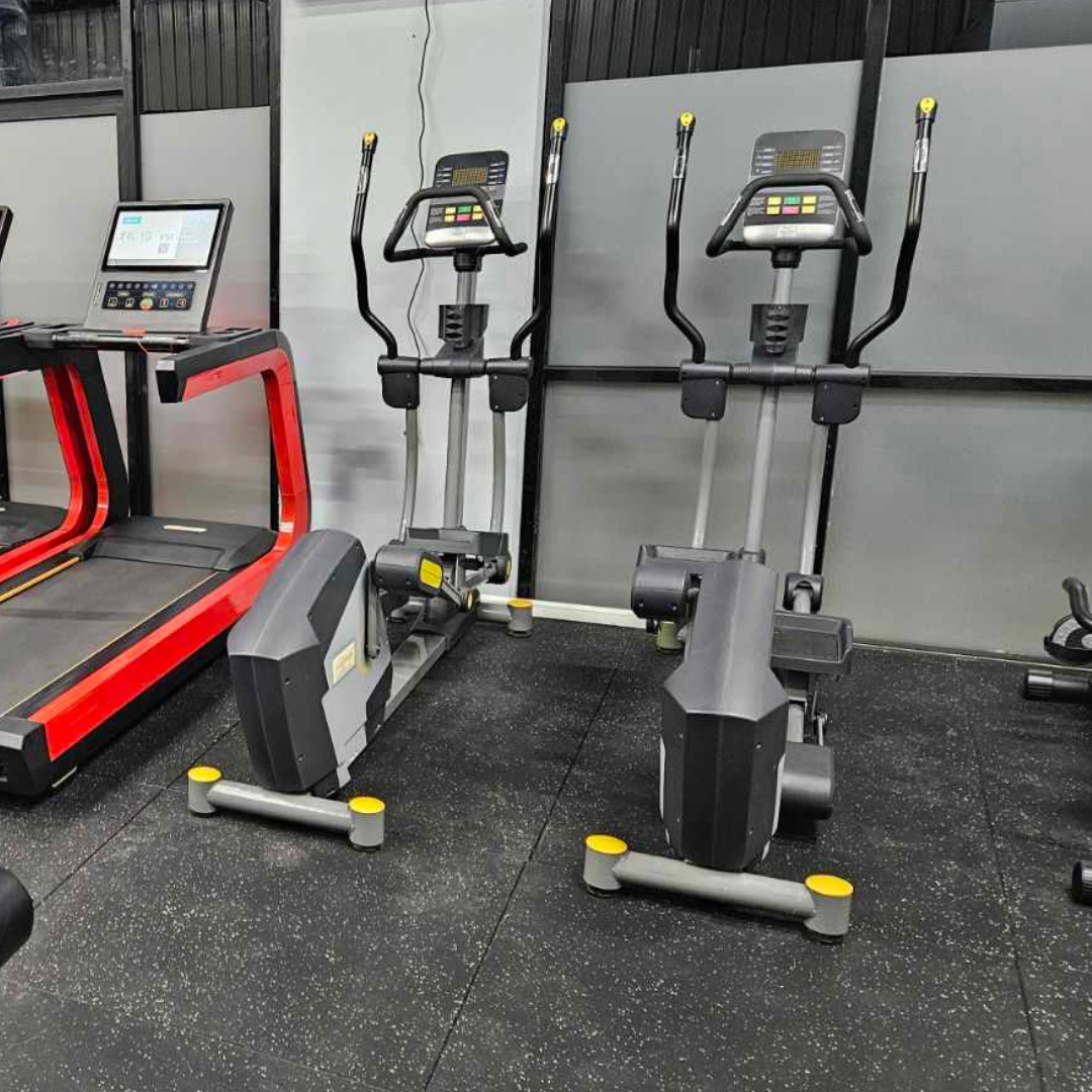 The photo shows a gym floor with two ellipticals and a treadmill.