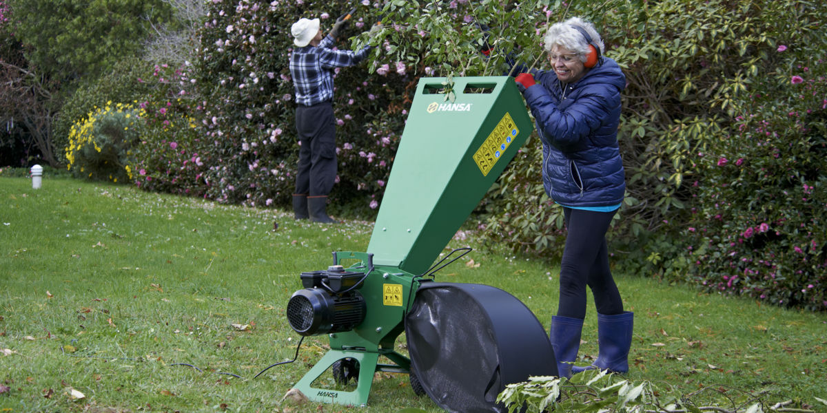 Woman using garden wood chipper