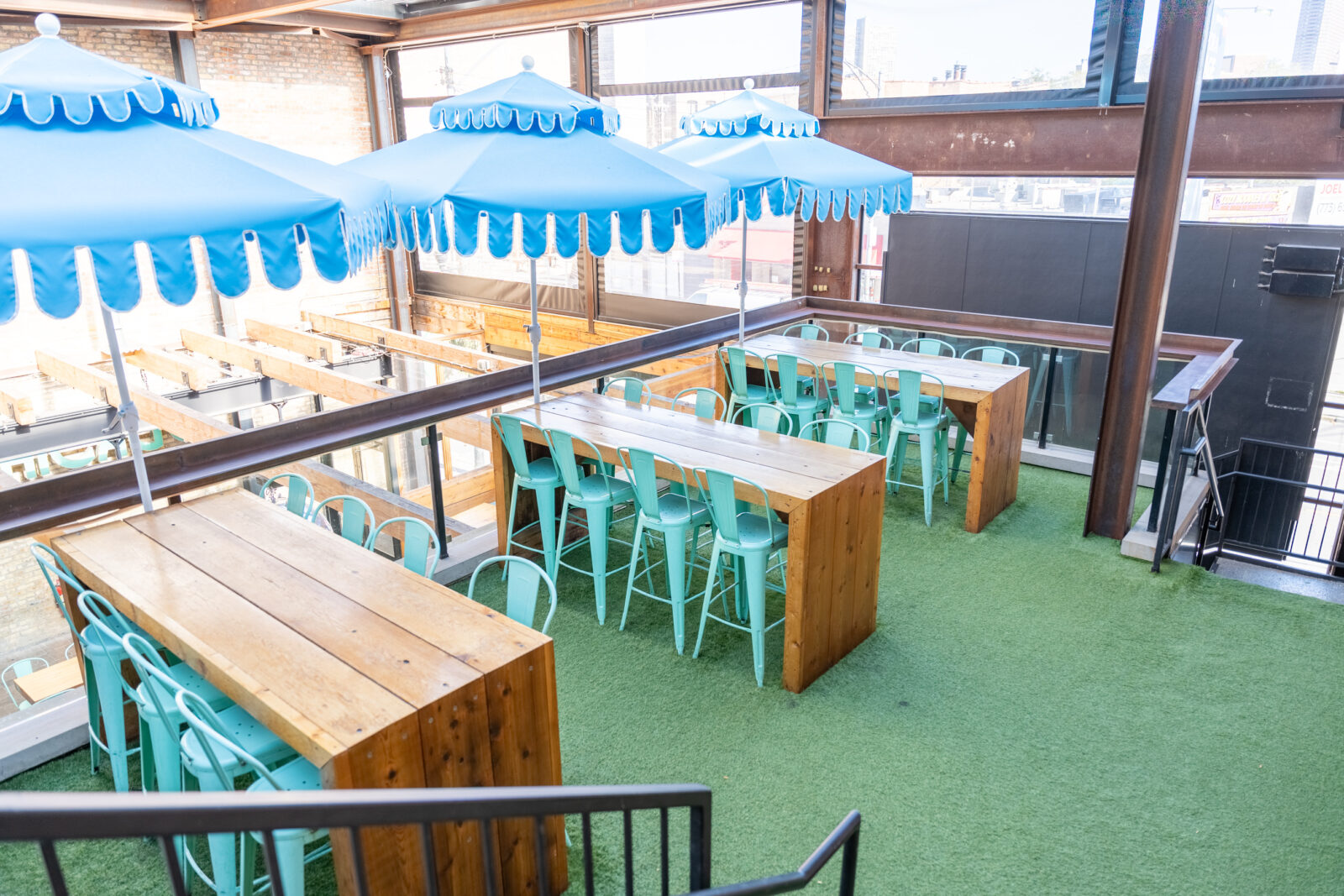 slide 1 of 1 - Second floor rooftop terrace, long hightop tables, blue umbrellas