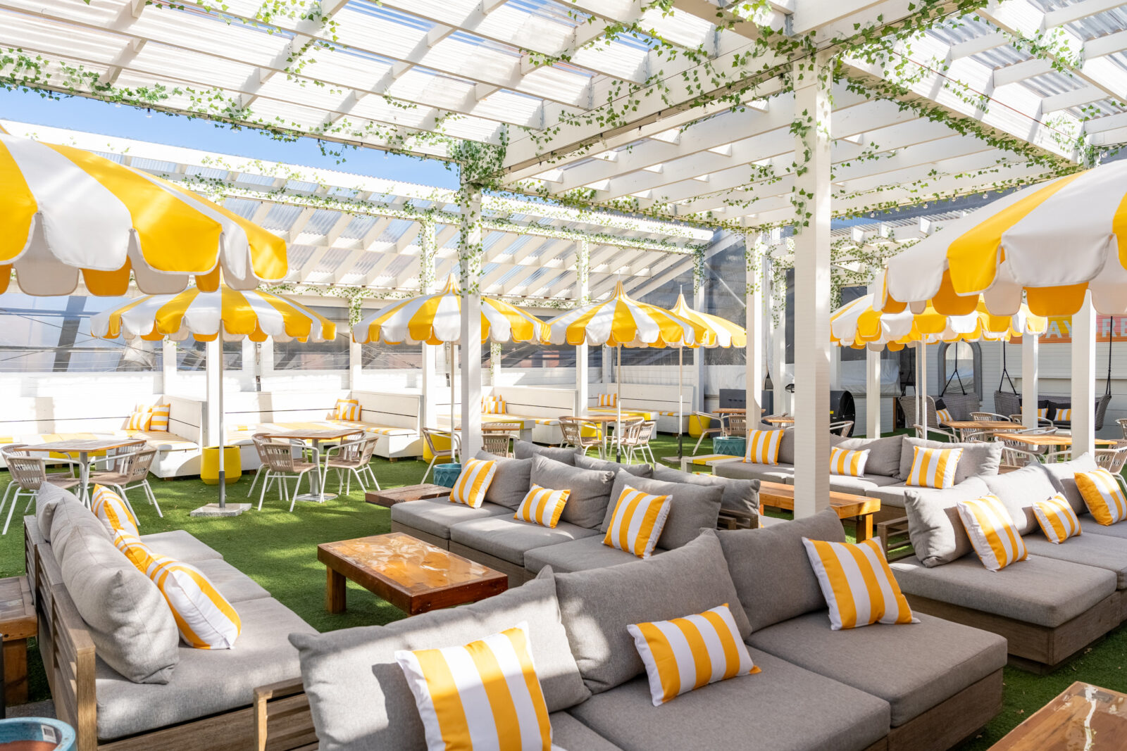 Rooftop seating, couches and lounge areas, yellow and whote umbrellas