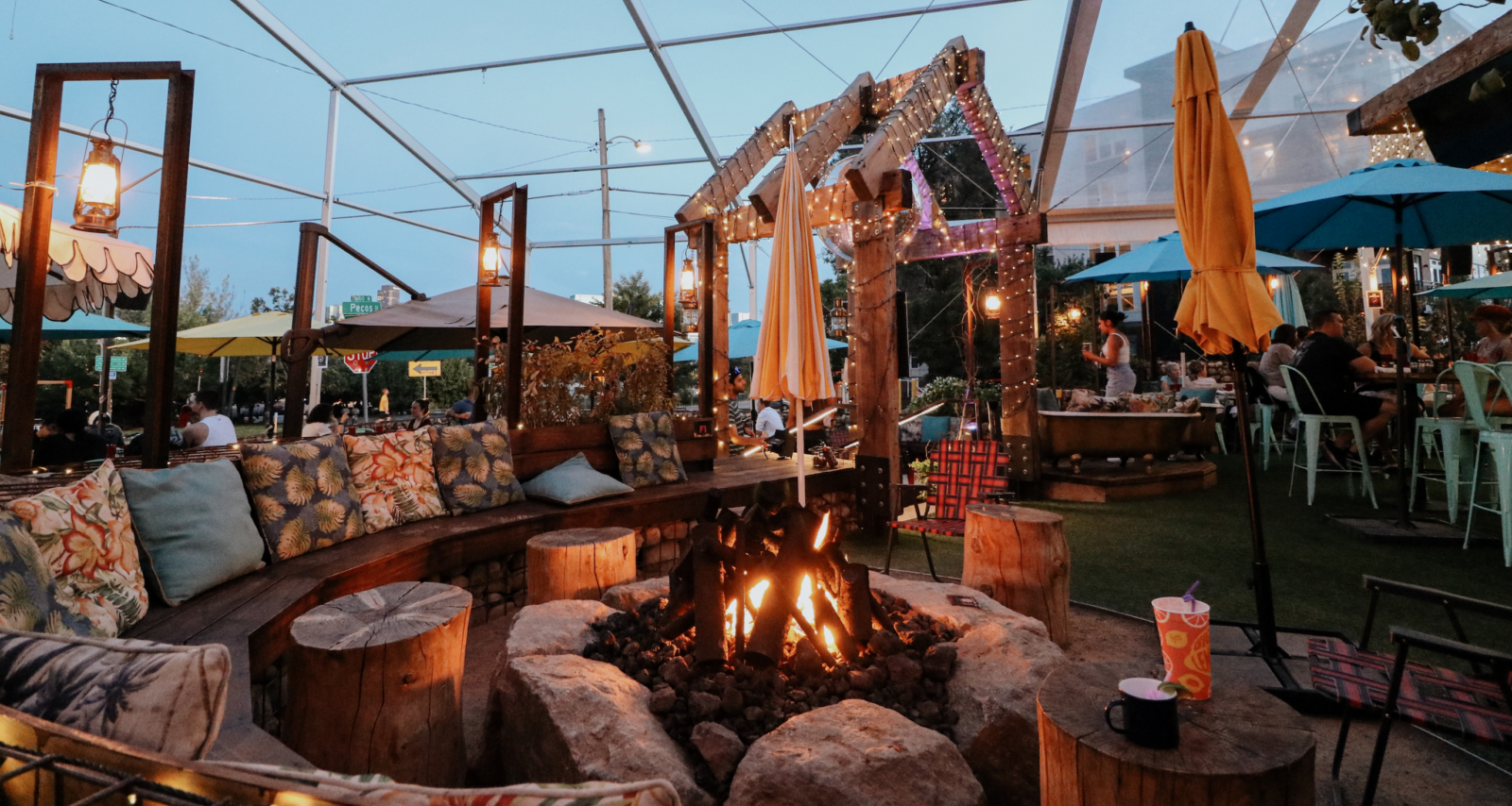 Happy Camper Denver Patio at night featuring our lit fire pit table