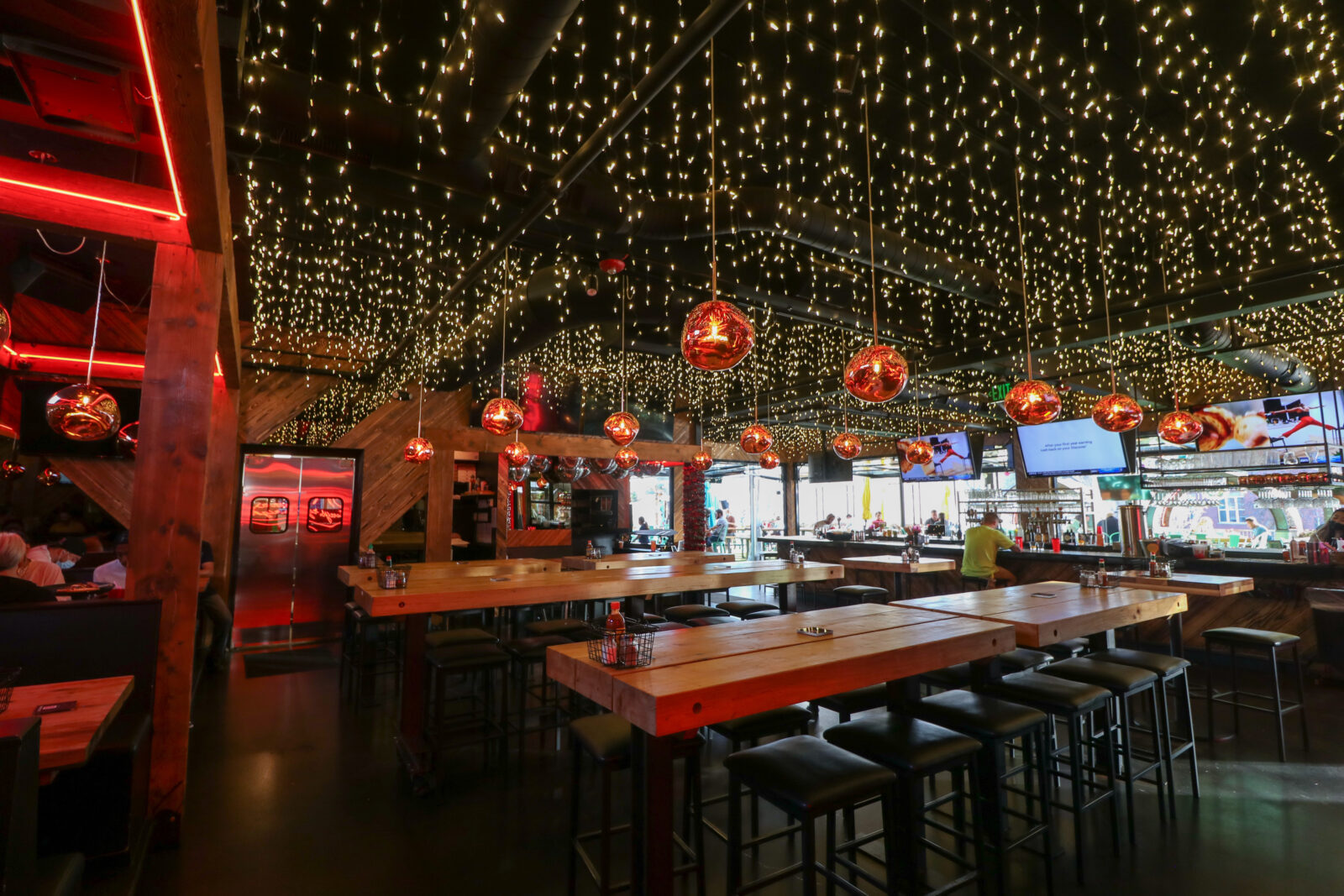 slide 1 of 1 - Indoor seating with long communal high tops, and a bar