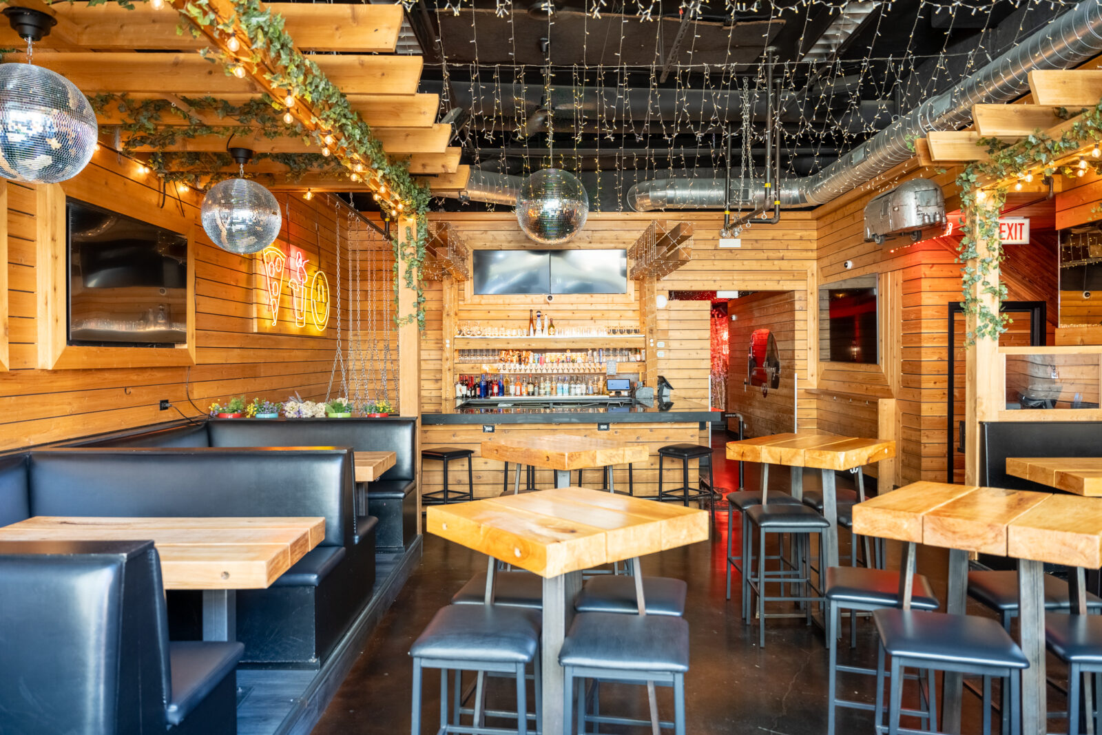 slide 1 of 3 - Indoor booth seating and high top tables, disco ball over the bar