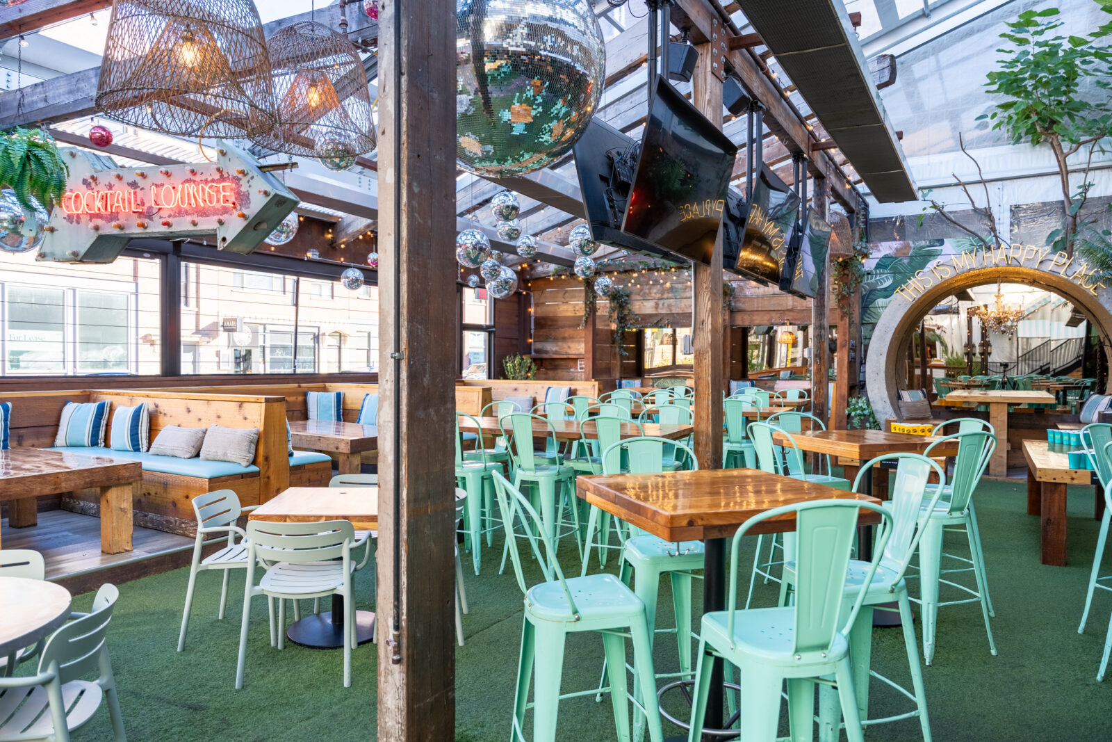 slide 2 of 3 - Patio space with high top seating, tvs, disco balls and retractable windows