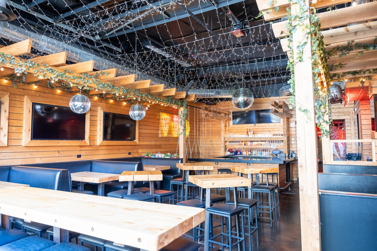 slide 3 of 3 - Indoor booth and high top seating, disco balls and a bar