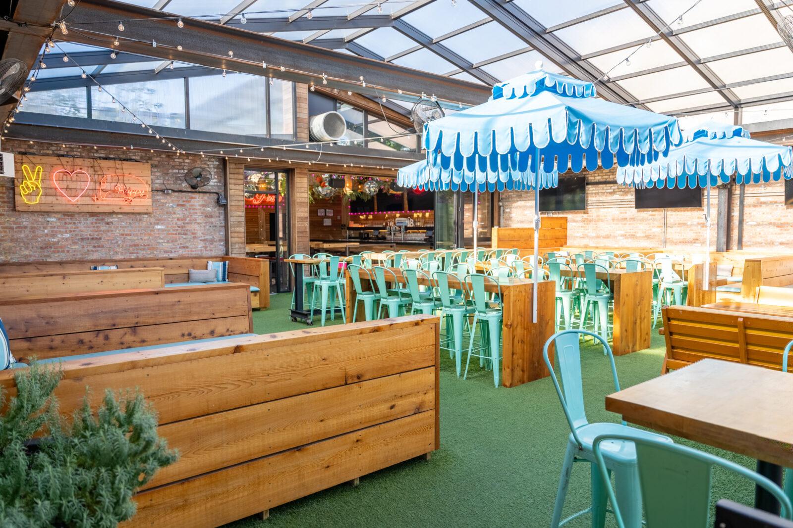 slide 1 of 2 - Rooftop space with long high top tables, cabana booth