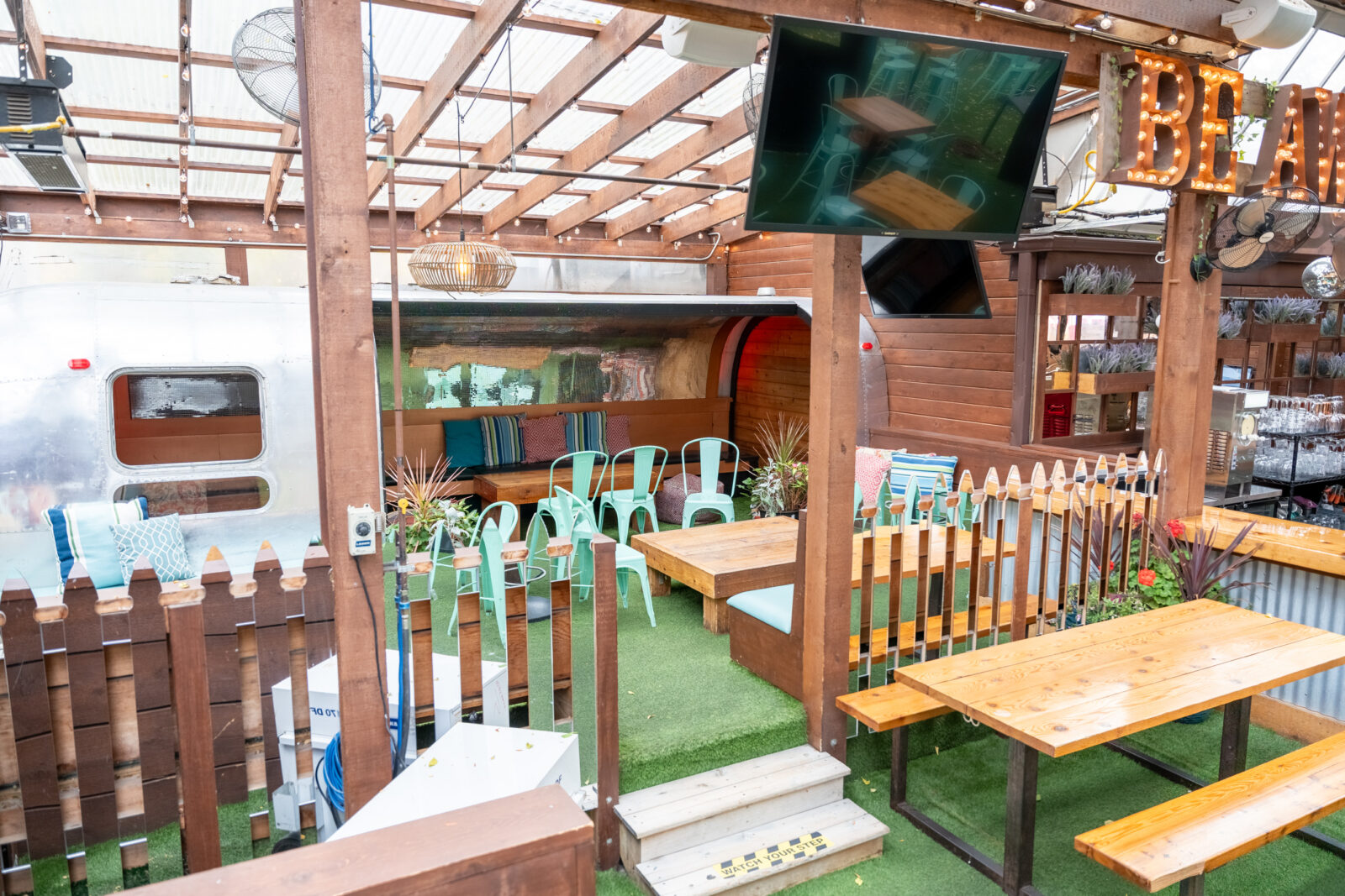slide 1 of 1 - Airstream trailer, seating in camper, steps leading up to enclosed seating area with turf