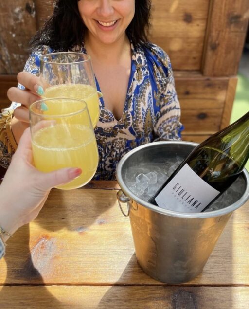 two women cheersing mimosas