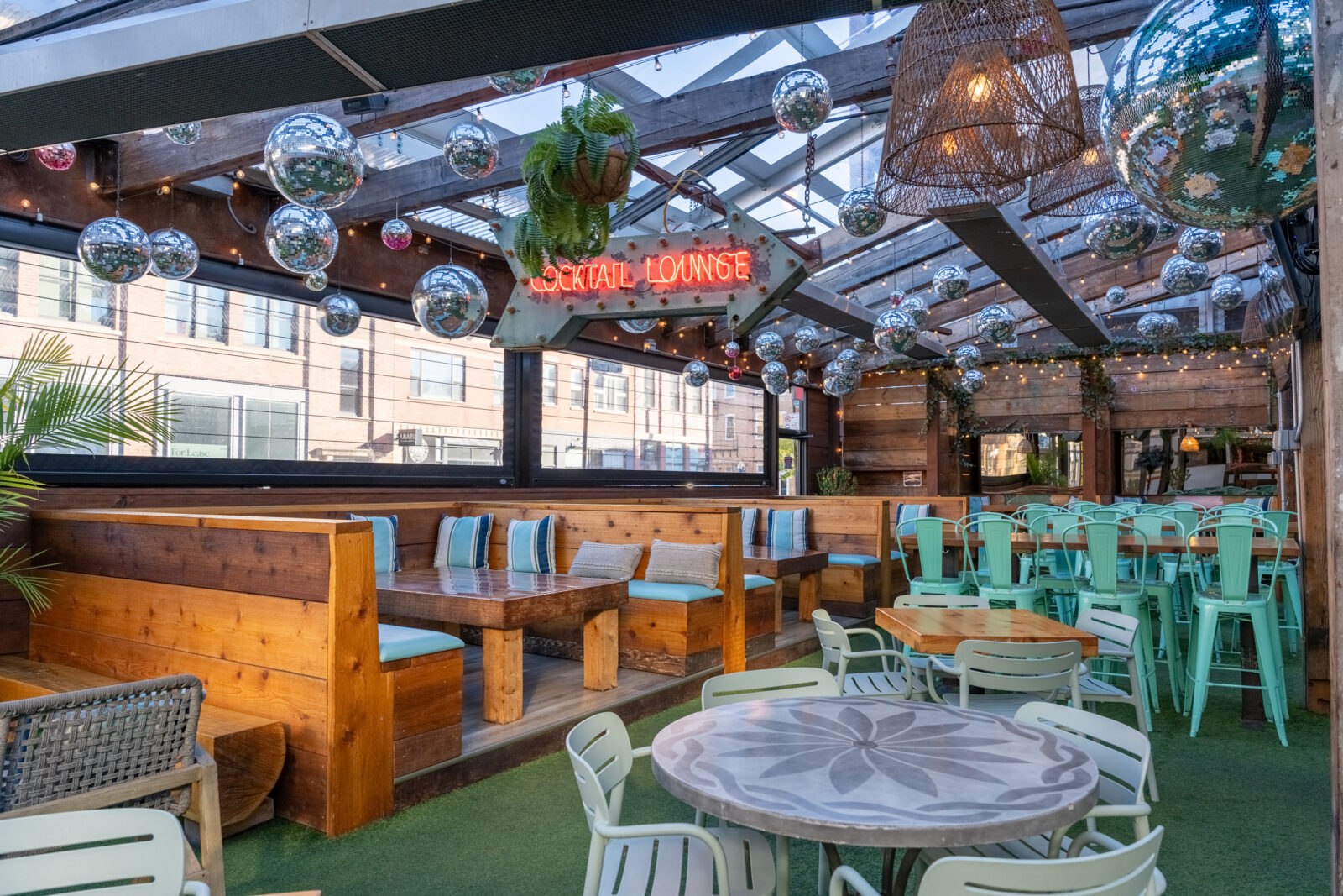 slide 1 of 3 - Patio seating with large cabanas, high tops, low tops, neon signs and disco balls
