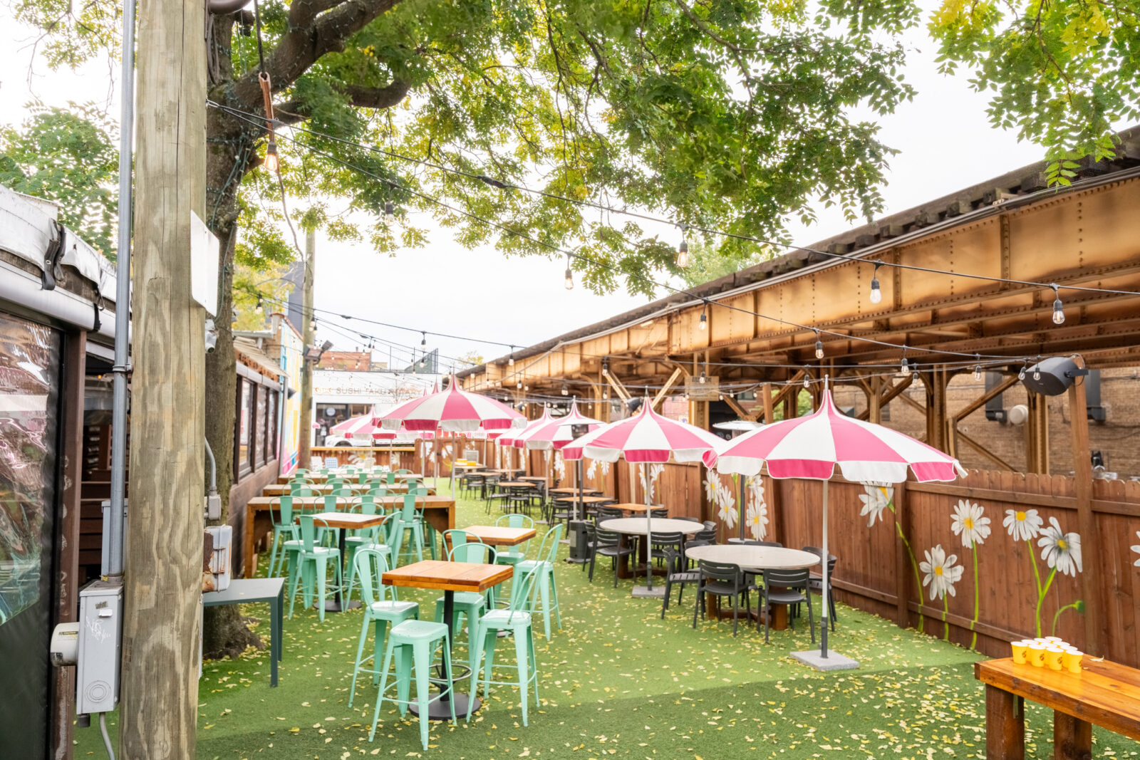 slide 1 of 4 - Outdoor patio, high top seating, pink and white umbrellas