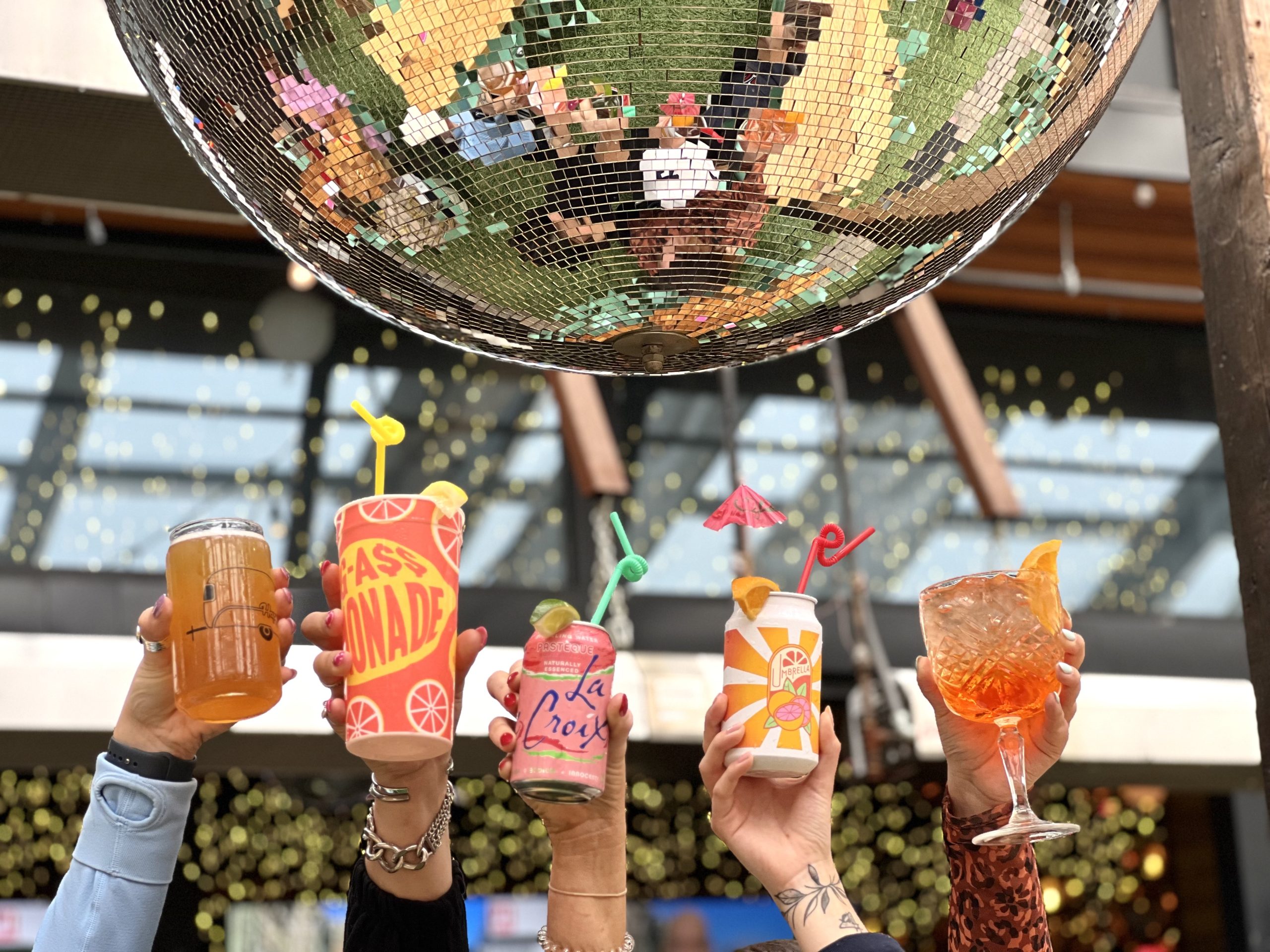 things to do in las vegas - group of cocktails held up below a disco ball