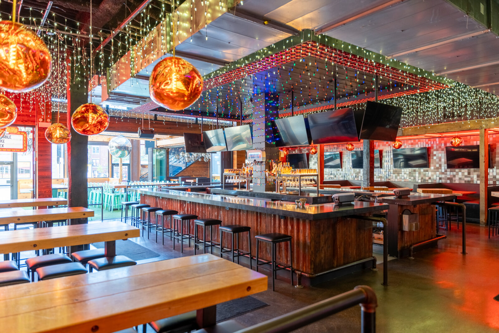 slide 1 of 2 - Large indoor space with 360 bar in the middle, hightop tables, Christmas lights, tvs and accordion wondows