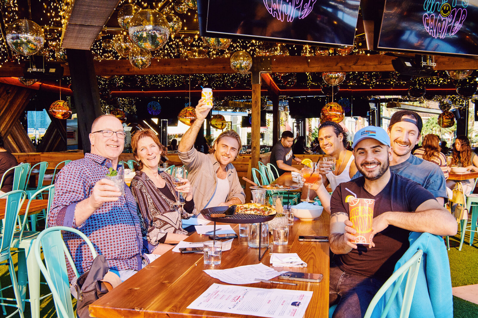 A group of guests dining at Happy Camper and smiling toward the camera.