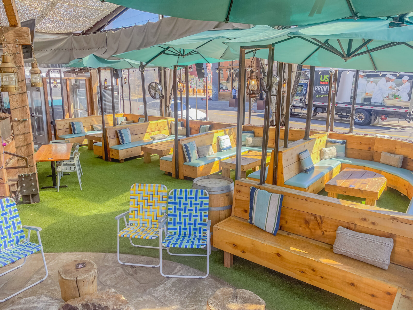 slide 3 of 3 - Multiple cabanas on a patio with multi-colored umbrellas