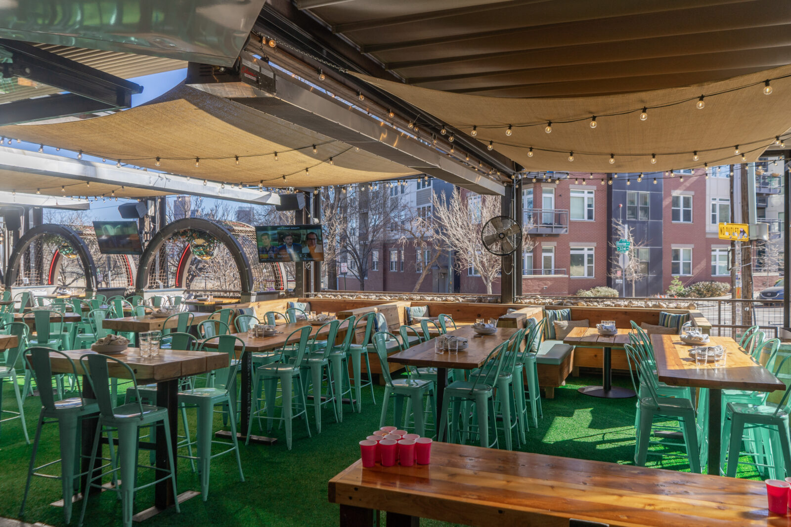 slide 1 of 3 - Patio seating with high and low top tables, beer pong, tvs