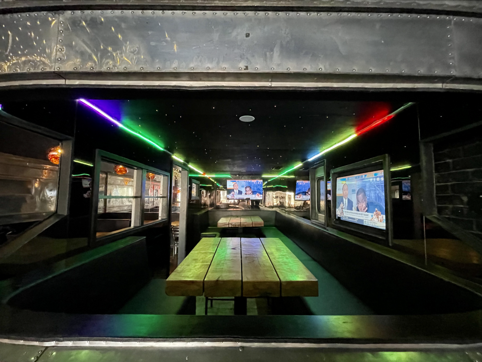 slide 2 of 2 - Inside airstream camper with booth seating and neon rope lights